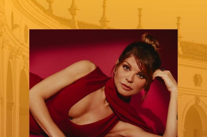 Donna in abito rosso, posa elegante e intensa.